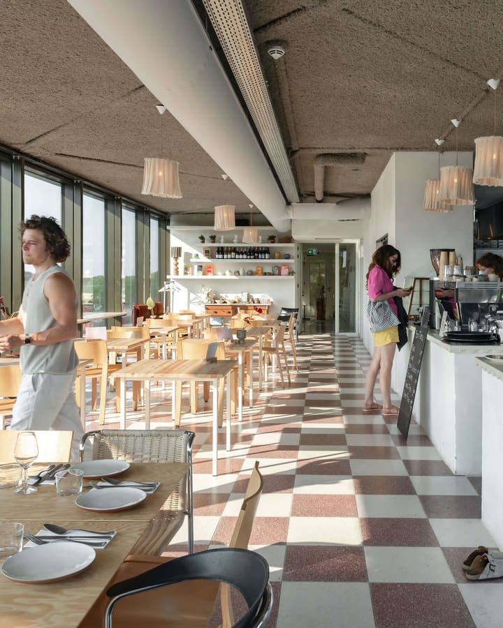 The café-restaurant interior with a long bar and large windows onto the square