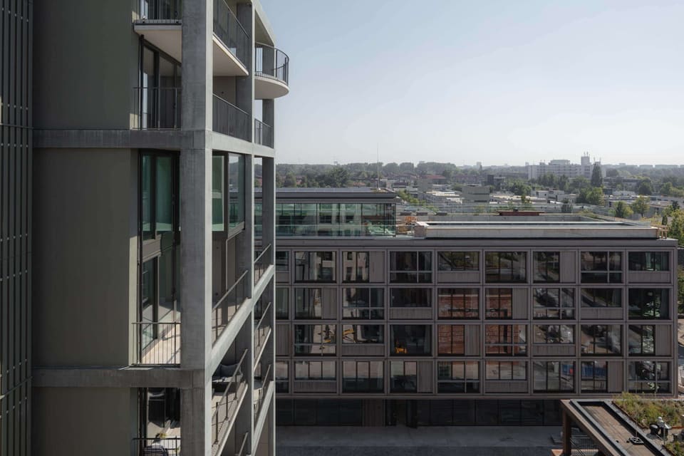 The white profiled-concrete residential block against the Amsterdam skyline