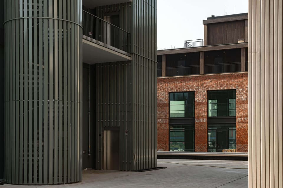 The green concrete tower rising above the brick plinth