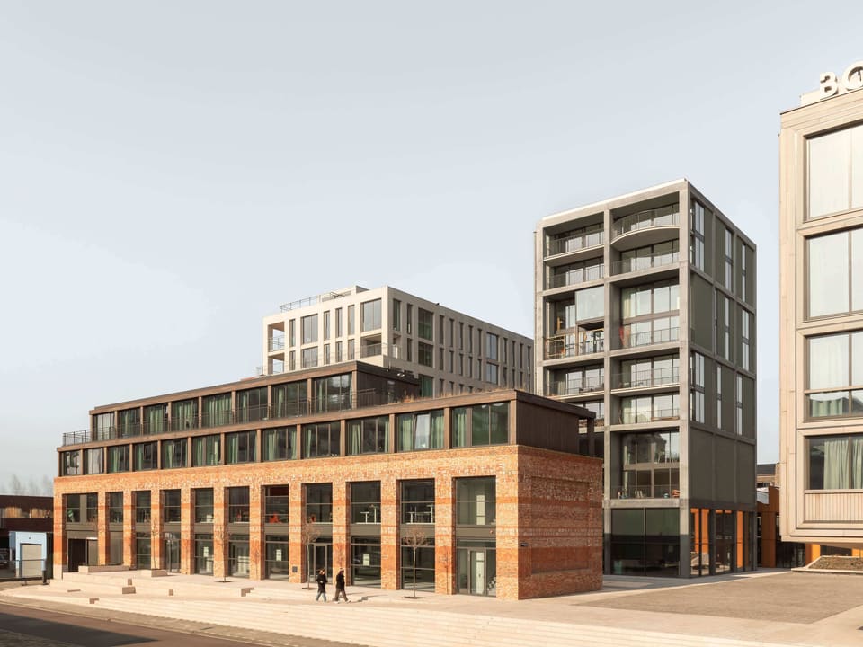 Republica: recycled-brick restaurant building and the residential towers on the natural-stone village square